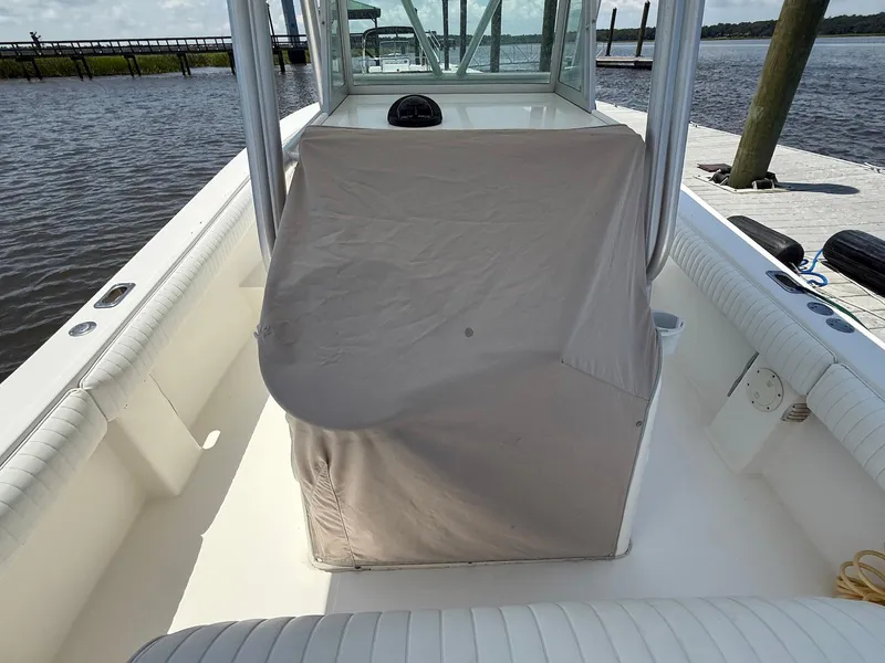 Slide: The Image of 2006 Regulator 26 Forward Seating boat interior with covered console, docked by the water. - 7