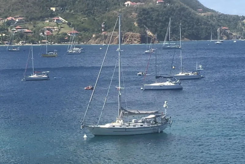Slide: The Image of Sailboats anchored in a scenic bay, featuring a 2004 Pacific Seacraft 40. - 3