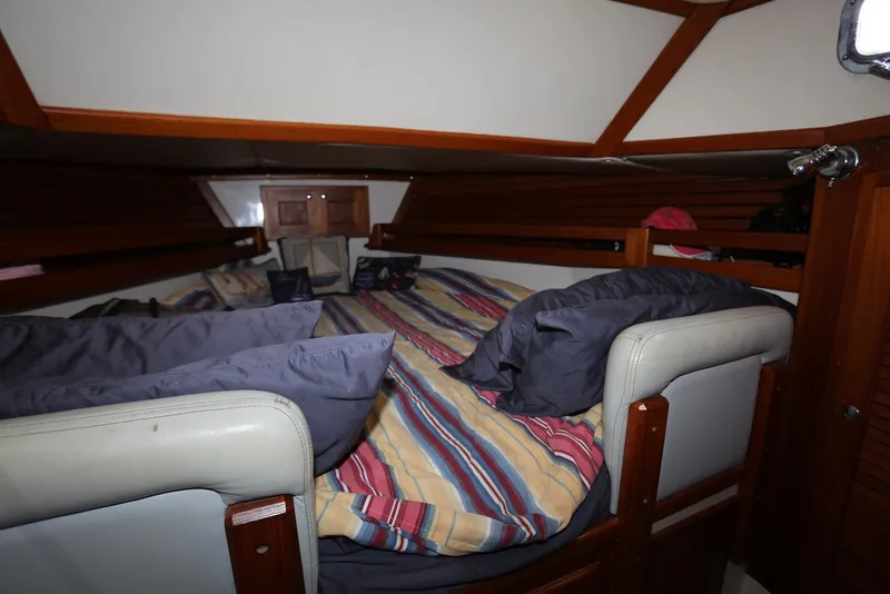 Slide: The Image of Cozy cabin interior of 2004 Pacific Seacraft Crealock 40 sailboat with striped bedding. - 34
