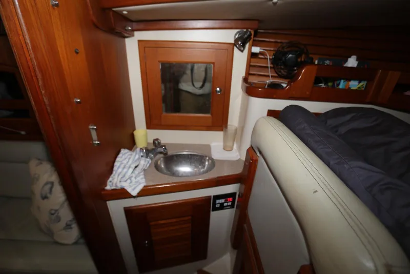 Slide: The Image of Interior of 2004 Pacific Seacraft Crealock 40 yacht, featuring a compact sink and wooden cabinetry. - 37