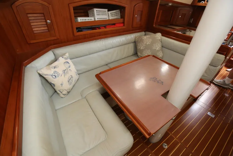 Slide: The Image of Cozy interior of 2004 Pacific Seacraft Crealock 40 sailboat with cushioned seating and wooden table. - 42