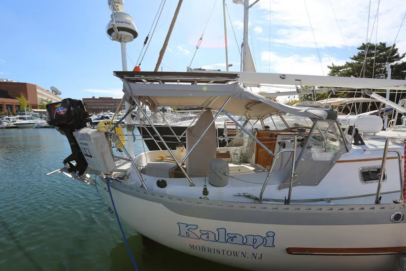 Slide: The Image of 2004 Pacific Seacraft Crealock 40 sailboat docked in a marina, featuring a covered cockpit. - 9