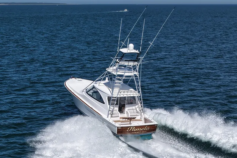Slide: The Image of 2024 Viking 48 Sport Tower cruising on open water, creating a dynamic wake. - 1