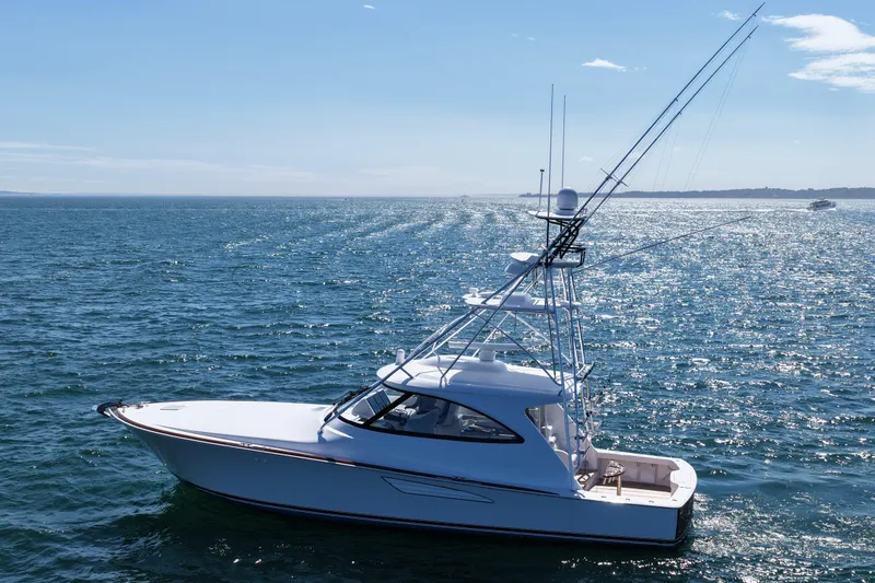 Slide: The Image of 2024 Viking 48 Sport Tower yacht cruising on open sea under clear blue sky. - 15