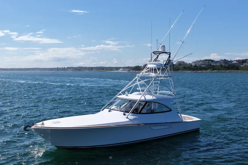 Slide: The Image of 2024 Viking 48 Sport Tower yacht on open water under clear blue sky. - 17