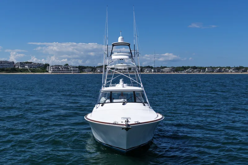 Slide: The Image of 2024 Viking 48 Sport Tower yacht on open water, coastal town in background. - 18