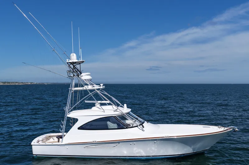 Slide: The Image of 2024 Viking 48 Sport Tower yacht on open sea under clear blue sky. - 21