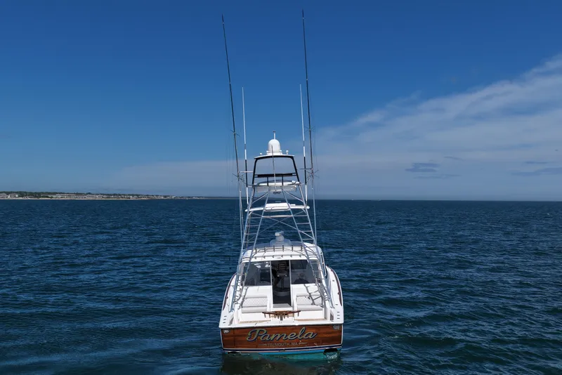 Slide: The Image of 2024 Viking 48 Sport Tower yacht on open sea under clear blue sky. - 24