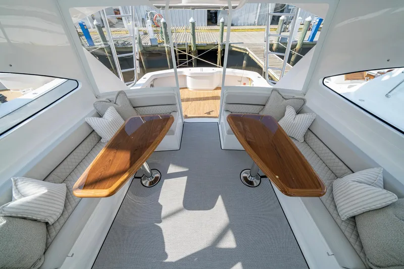 Slide: The Image of 2024 Viking 48 Sport Tower interior with elegant seating and wooden tables. - 32