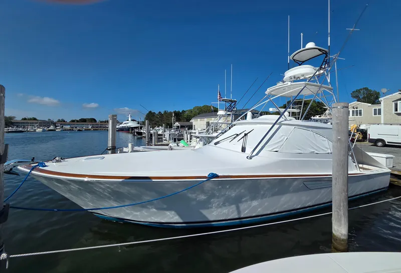 Slide: The Image of 2024 Viking 48 Sport Tower yacht docked at marina under clear blue sky. - 30