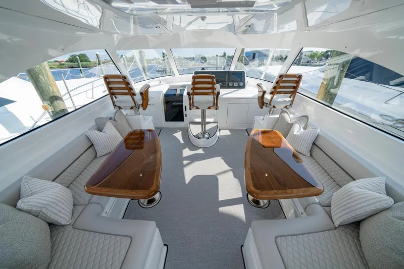 Slide: The Image of Luxurious interior of 2024 Viking 48 Sport Tower yacht with elegant seating and wooden tables. - 31
