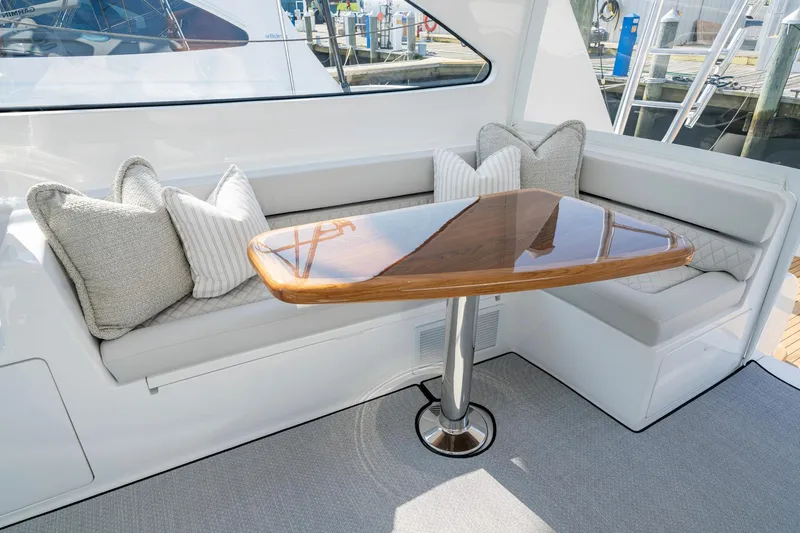 Slide: The Image of 2024 Viking 48 Sport Tower interior with elegant seating and polished wooden table. - 35