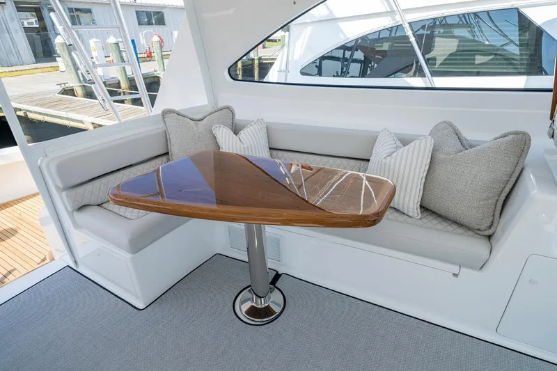 Slide: The Image of 2024 Viking 48 Sport Tower interior with elegant seating and polished wooden table. - 36