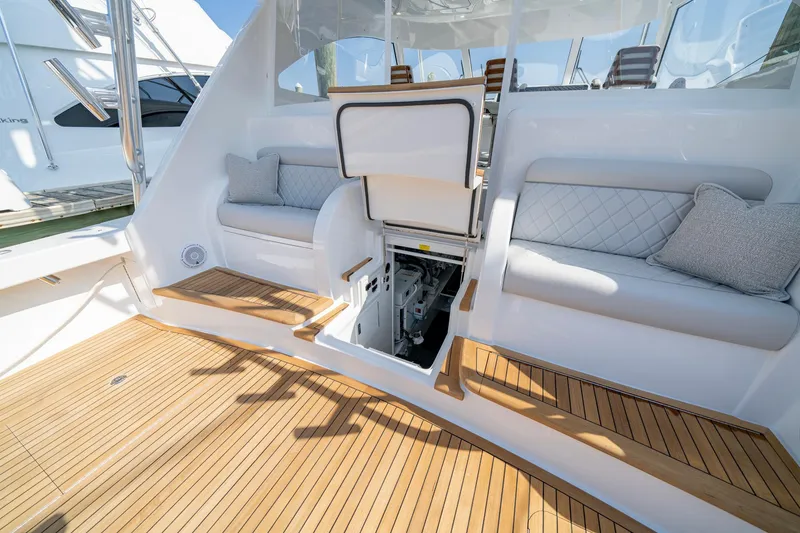 Slide: The Image of 2024 Viking 48 Sport Tower yacht with open hatch, teak deck, and cushioned seating. - 50