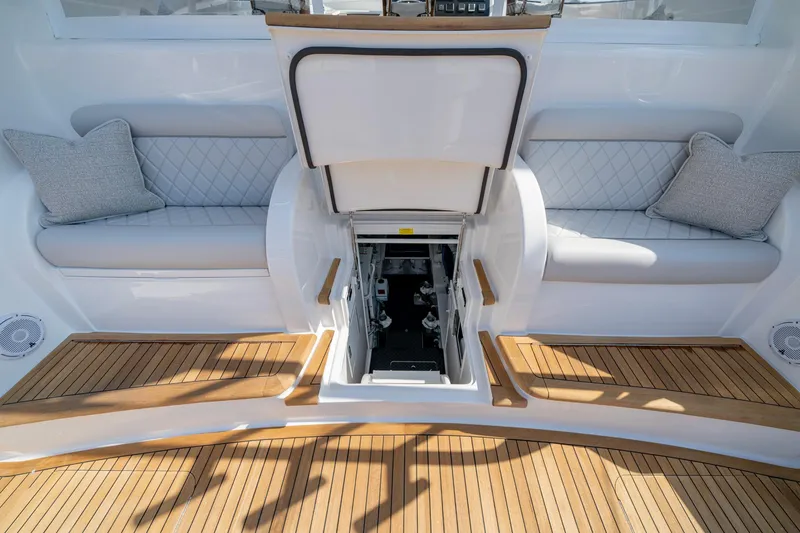 Slide: The Image of 2024 Viking 48 Sport Tower interior with teak flooring and cushioned seating. - 51