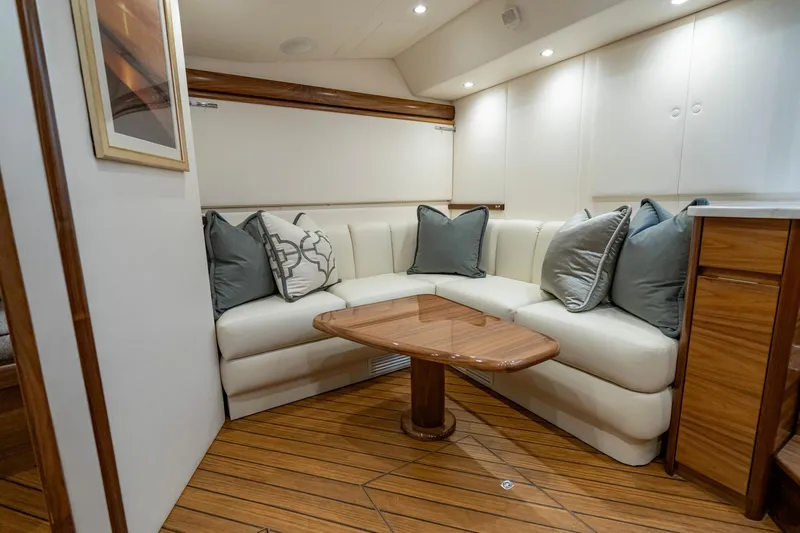 Slide: The Image of 2024 Viking 48 Sport Tower interior with elegant seating and wooden table. - 58
