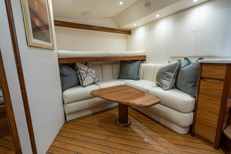 Slide: The Image of 2024 Viking 48 Sport Tower interior with elegant wood flooring and cozy seating area. - 59