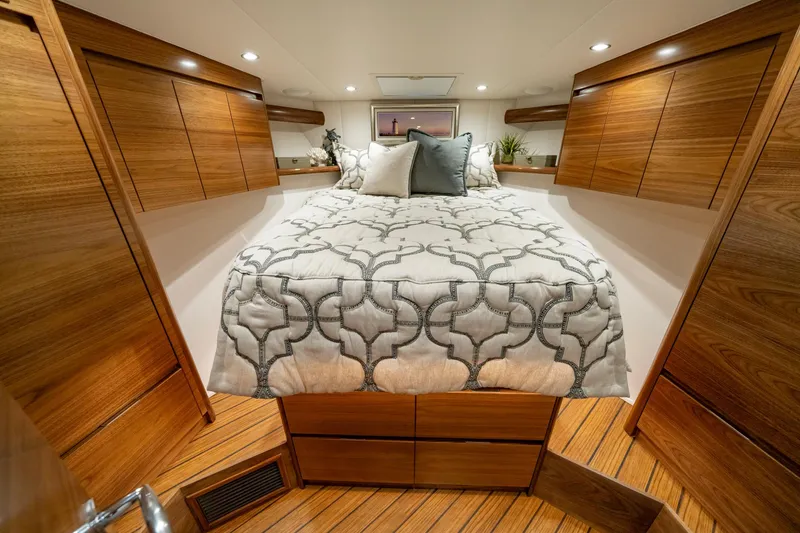 Slide: The Image of 2024 Viking 48 Sport Tower cabin with elegant wood finish and cozy bedding. - 65