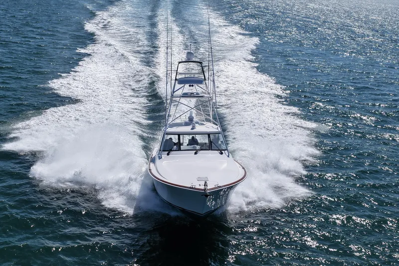 Slide: The Image of 2024 Viking 48 Sport Tower cruising on open water, creating a dynamic wake. - 6
