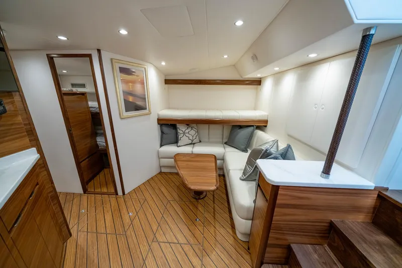 Slide: The Image of 2024 Viking 48 Sport Tower interior with elegant seating and wooden table. - 60