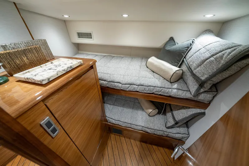 Slide: The Image of 2024 Viking 48 Sport Tower cabin with elegant wood finish and cozy bedding. - 65