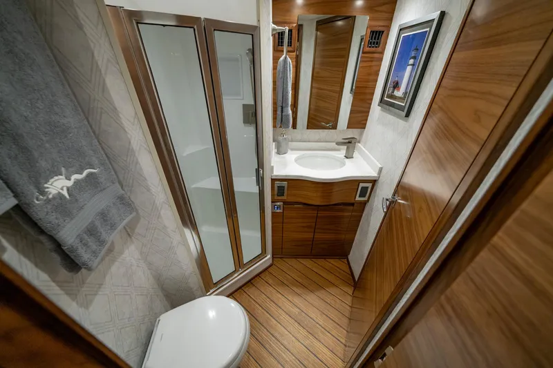 Slide: The Image of Luxurious bathroom in 2024 Viking 48 Sport Tower yacht with modern fixtures and wood accents. - 68
