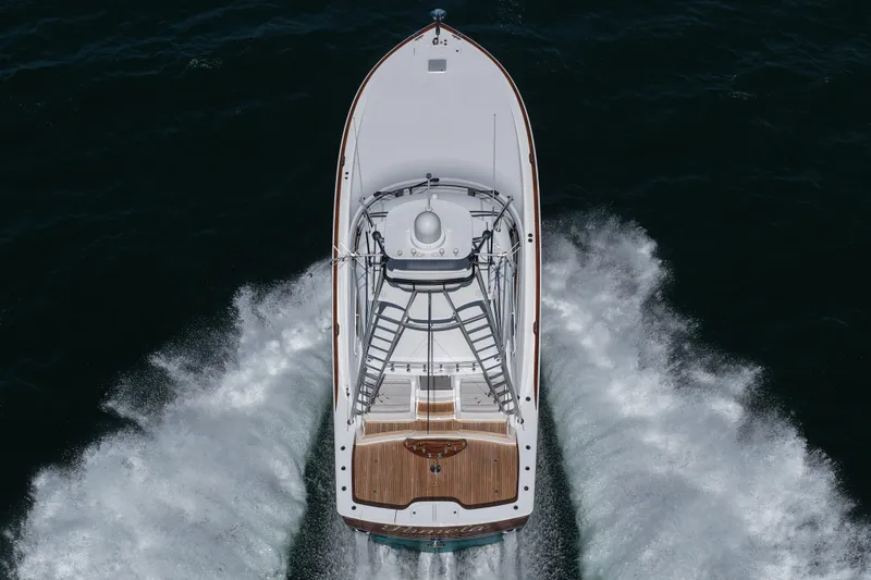 Slide: The Image of 2024 Viking 48 Sport Tower yacht cruising on open water, aerial view. - 13