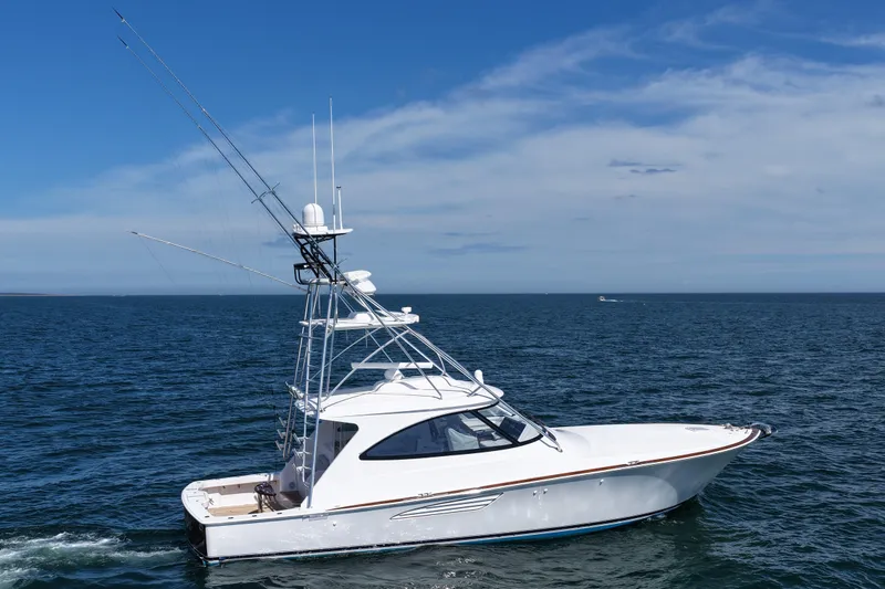 Slide: The Image of 2024 Viking 48 Sport Tower yacht cruising on open sea under clear blue sky. - 22