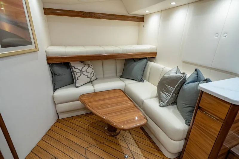 Slide: The Image of 2024 Viking 48 Sport Tower interior with elegant seating and wooden table. - 60