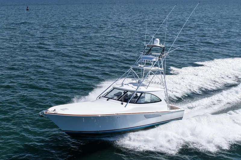 Slide: The Image of 2024 Viking 48 Sport Tower yacht cruising on open water. - 8