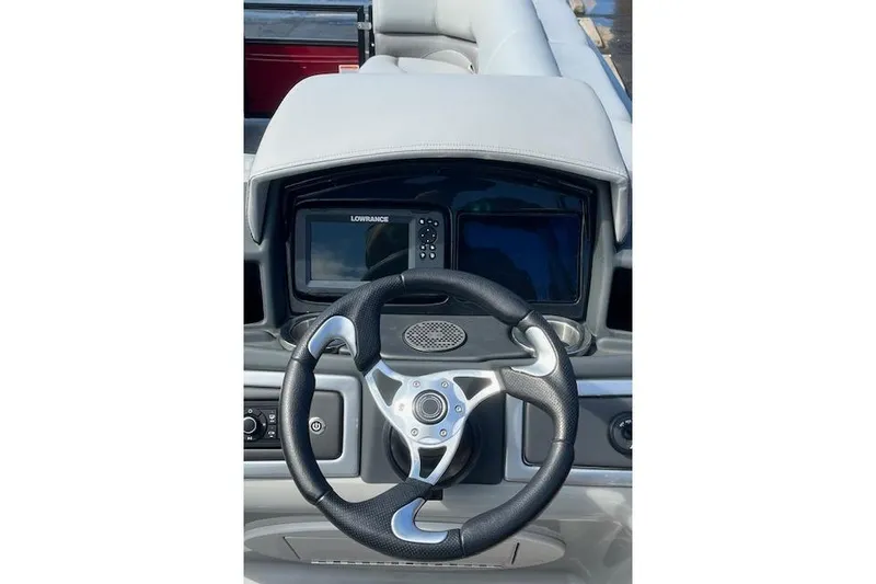 Slide: The Image of 2024 Regency 250 DL3 boat dashboard with steering wheel and Lowrance display. - 15