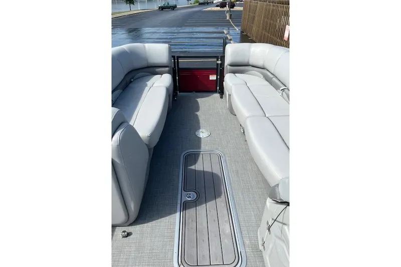 Slide: The Image of 2024 Regency 250 DL3 pontoon boat interior with gray seating and flooring. - 16