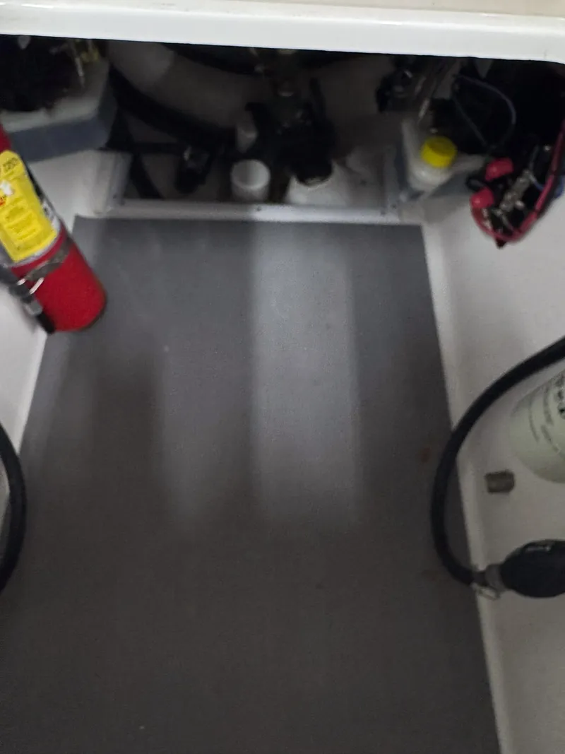 Slide: The Image of Interior view of a 2022 Contender 32 ST boat compartment with fire extinguisher and equipment. - 17