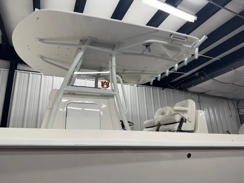Slide: The Image of 2022 Contender 32 ST boat in a warehouse, featuring a sleek T-top and seating. - 3