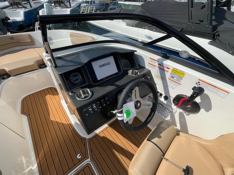 Slide: The Image of 2025 Bayliner VR6 Bowrider OB cockpit with Simrad display and tan seating. - 10