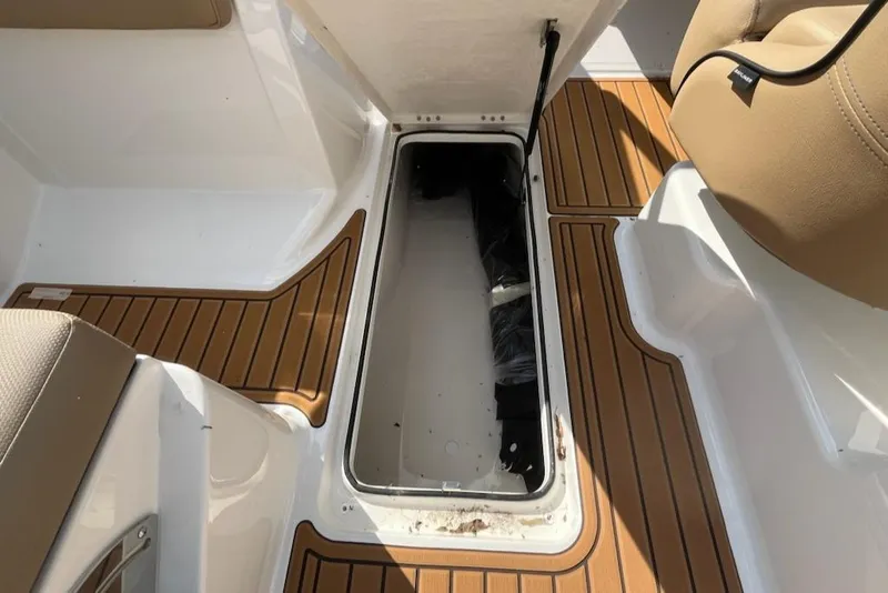 Slide: The Image of 2025 Bayliner VR6 Bowrider OB interior storage compartment with teak-style flooring. - 13