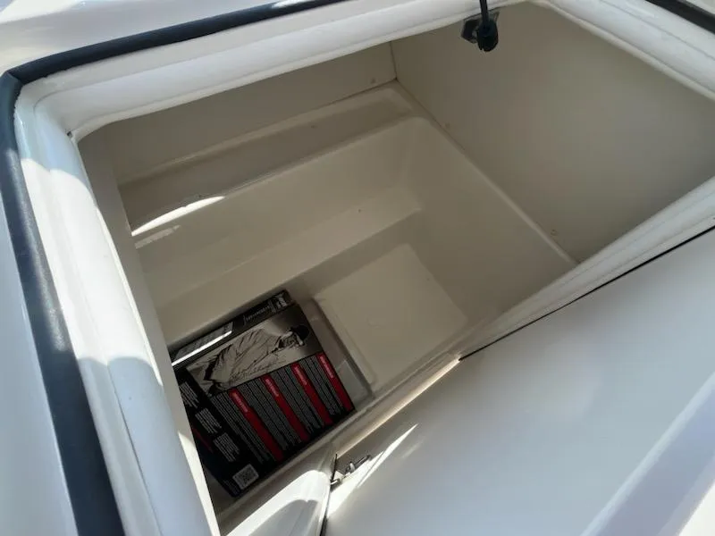 Slide: The Image of 2025 Bayliner VR6 Bowrider OB storage compartment with box inside. - 15
