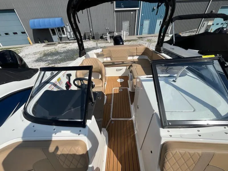 Slide: The Image of 2025 Bayliner VR6 Bowrider OB interior with tan seating and wood-style flooring. - 16