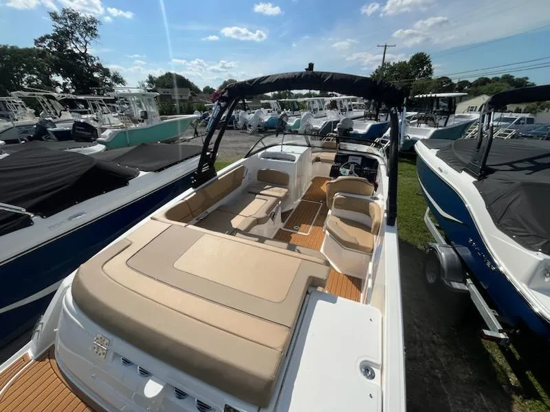 Slide: The Image of 2025 Bayliner VR6 Bowrider OB with spacious seating and sleek design in a boatyard. - 4