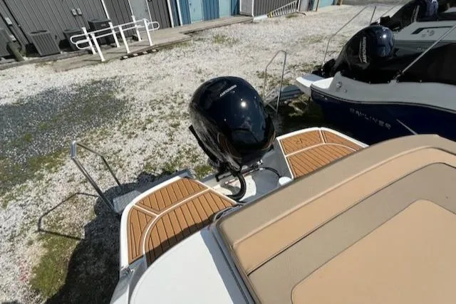 Slide: The Image of 2025 Bayliner VR6 Bowrider OB with outboard motor, docked on gravel surface. - 6