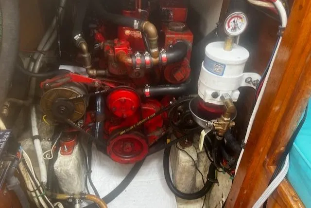 Slide: The Image of Engine compartment of a 1981 Bristol 35.5 sailboat, featuring red mechanical components and hoses. - 25