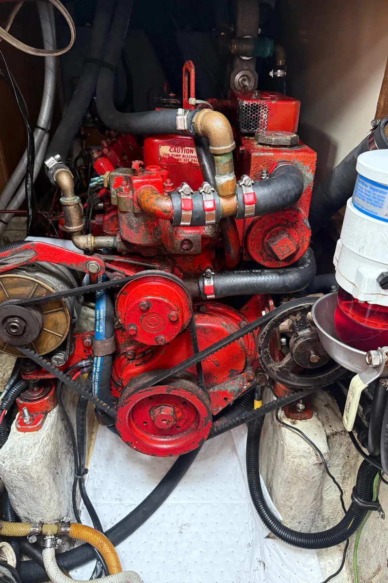 Slide: The Image of Engine of a 1981 Bristol 35.5 sailboat, featuring red components and various hoses. - 27