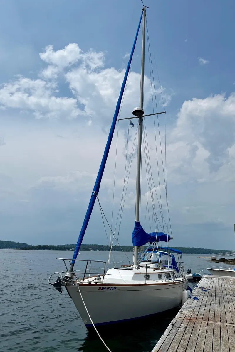 Slide: The Image of 1981 Bristol 35.5 sailboat docked by a wooden pier under a cloudy sky. - 28