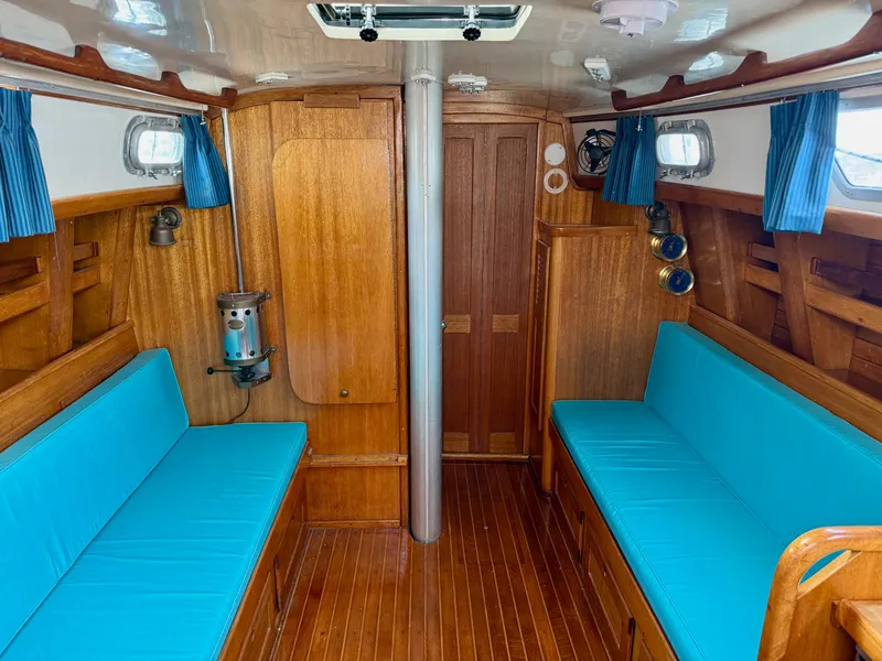 Slide: The Image of Interior of 1981 Bristol 35.5 sailboat with wooden finish and blue cushions. - 3