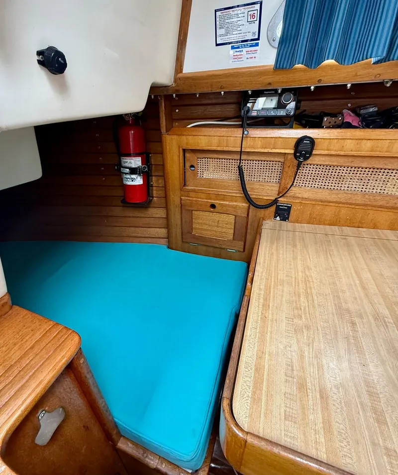 Slide: The Image of Interior of a 1981 Bristol 35.5 sailboat with wooden cabinetry and turquoise cushion. - 9