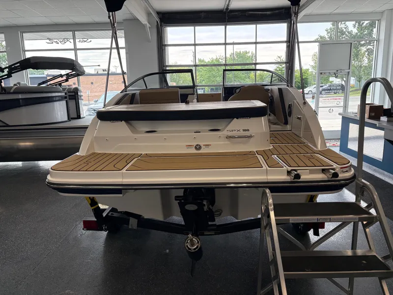 Slide: The Image of 2025 Sea Ray SPX 190 boat displayed indoors, showcasing rear deck and seating area. - 4