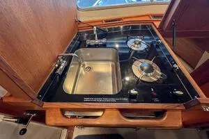 Slide: The Image of 2022 Targa 32 yacht kitchen with sink and dual-burner stove. - 22