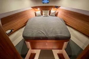 Slide: The Image of 2022 Targa 32 cabin interior with cozy bed and wooden finish. - 33