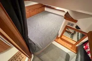 Slide: The Image of 2022 Targa 32 cabin interior with bed, wooden accents, and mirror. - 35