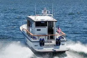 Slide: The Image of 2022 Targa 32 boat cruising on open water, rear view with American flag. - 44
